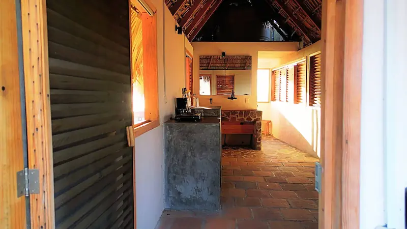 Entrance to SOL Suite with palm roof and stone floors / Entrada a Suite SOL con techo de palapa y pisos de piedra en CasaInspira