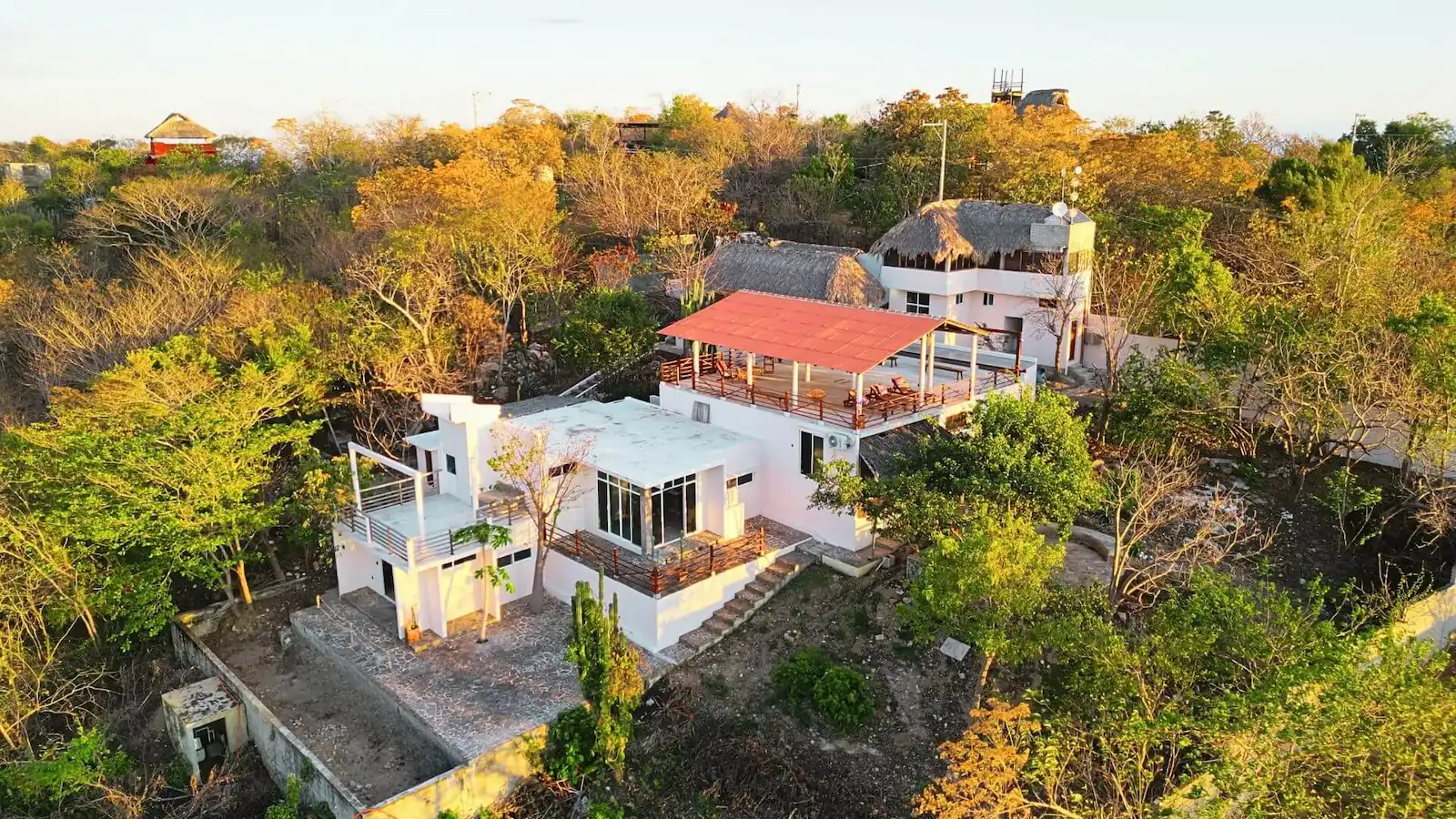 TIERRA Loft entrance with floor-to-ceiling windows, bed and gardens / Entrada a Loft TIERRA con ventanales de piso a techo, cama y jardines nativos